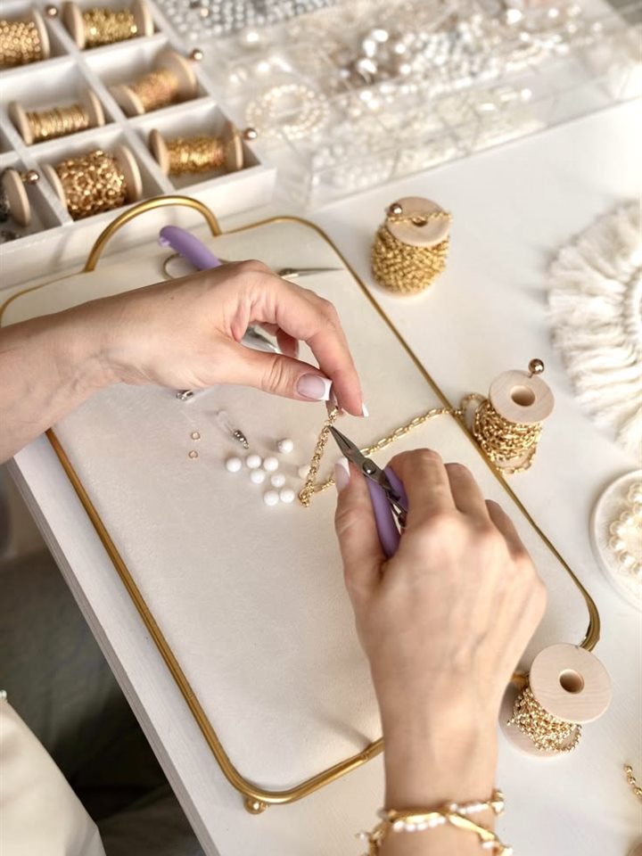Hands crafting jewellery representing product manufacturers